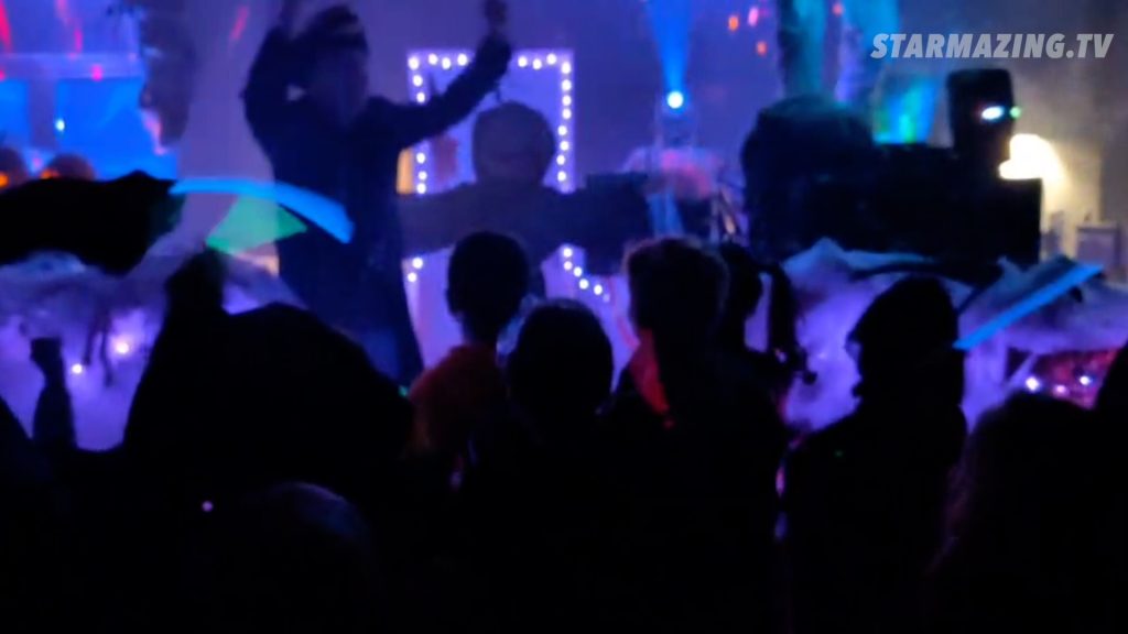 Halloween-Kapitän und Kinder rufen den Kürbiskönig herbei in Rheydt Der Halloween-Kapitän schwingt Leuchtstäbe und ruft zusammen mit einer Gruppe begeisterter Kinder den Kürbiskönig beim Halloween-Event in Rheydt herbei.