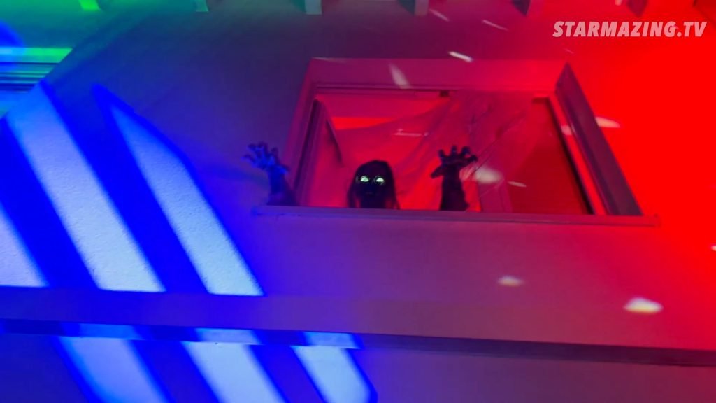 Vorgarten Halloween in Mönchengladbach Rheydt: Skelett mit grünen Leuchtaugen kriecht aus dem Fenster Unheimliches Skelett mit grünen Leuchtaugen kriecht aus dem Fenster beim Vorgarten Halloween in Mönchengladbach Rheydt