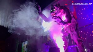 Riesiger Werwolf steht im Nebel vor dem Haus; der Kürbiskönig ist im Fenster des Halloween-Vorgartens in Mönchengladbach Rheydt zu sehen