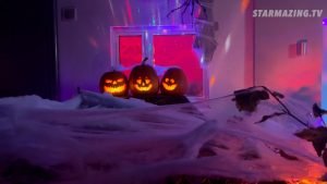 Schneeweißer Vorgarten durch Riesenspinnen-Netze beim Halloween-Event in Rheydt, aus denen drei fröhliche Kürbisse hervorschauen und die Kinder mit einer Show unterhalten.