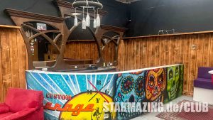 Stylischer Barbereich im Club Mönchengladbach mit auffälligem Bar-Kunstwerk