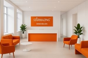 Moderner Empfangsbereich der STARMAZING Immobilienagentur mit weiß-oranger Einrichtung und zentralem Firmenschild.